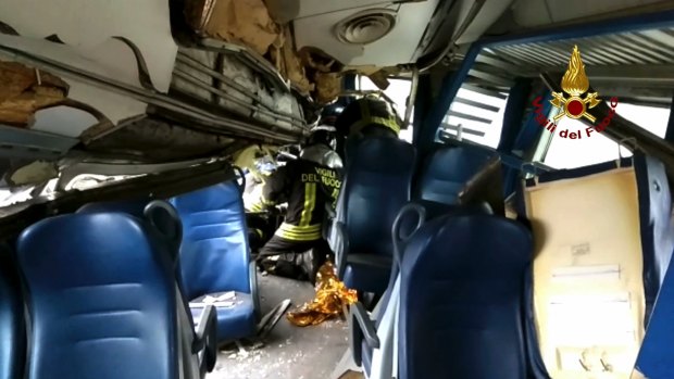Italian firefighters try to help a passenger out after the train derailed. 