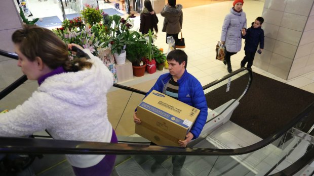 Panic buying: Russians in St Petersburg  grab bargains, fearing prices will rise due to the falling rouble. 