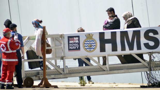 Migrants disembark from the British Naval ship HMS Bulwark at Taranto harbour on Saturday.