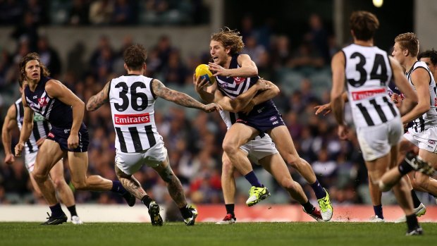 Fremantle's David Mundy looks to handball while under pressure from Collingwood.