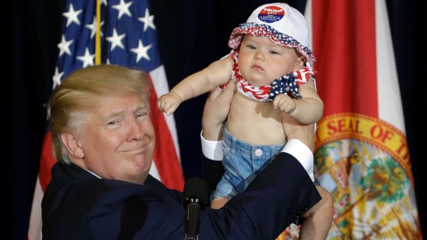 The final stretch: Donald Trump on stage with six-month-old Catalina Larkin in Florida.