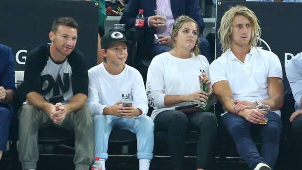 Brent Harvey (left) of North Melbourne and Dyson Heppell of Essendon and his partner Kate Turner watch the game.