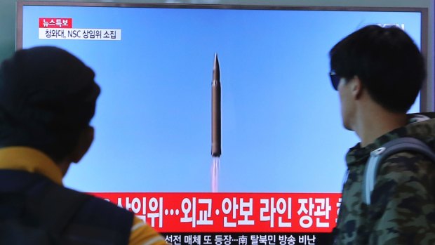 South Koreans watch a TV screen showing a file footage of North Korea's missile launch, at the Seoul Railway Station on Tuesday