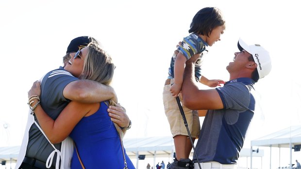 Jason Day celebrates with his son Dash, wife Ellie and caddie Colin Swatton.
