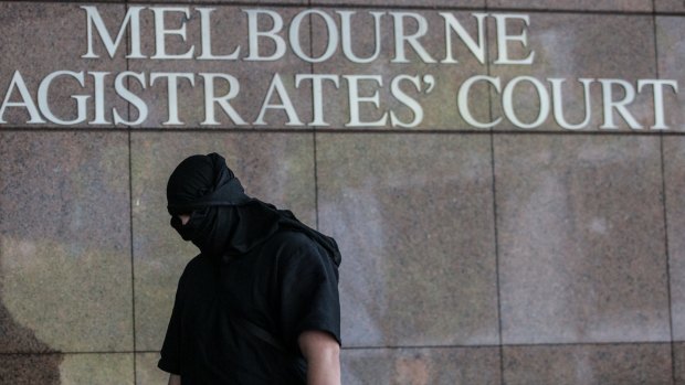 A hooded man arrives at Court to support the  five  alleged terror suspects on Thursday.