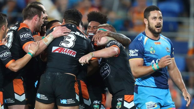 Up and down: Tigers players celebrate while Jarryd Hayne reacts to his side conceding a try.