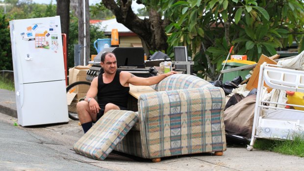 John Egan surveys his ruined possessions after flooding in Logan caused by ex-cyclone Debbie.