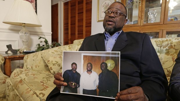 Anthony Scott holds a photo of himself, centre, and his brothers Walter (left) and Rodney, at his home near North Charleston, South Carolina. 