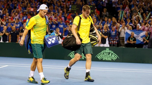 Lleyton Hewitt leaves the court with Sam Groth after his final Davis Cup match.