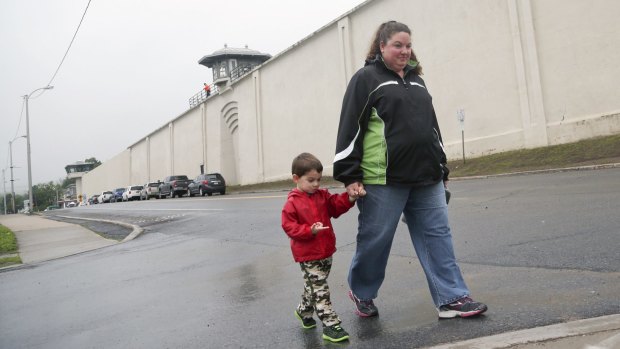 Stephanie Irwin and her son Samuel, 3, walk past Clinton Correctional Facility on their way to the post office on Monday in Dannemora, New York. 