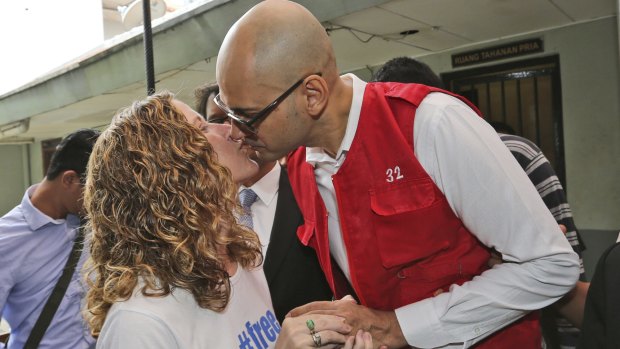 Canadian teacher Neil Bantleman, right, kisses his wife Tracy prior to the start of his trial hearing in December 2014.