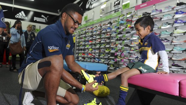 Henry Speight helps fit boots for six-year-old Aminda Weerasooriya of
O'Connor.