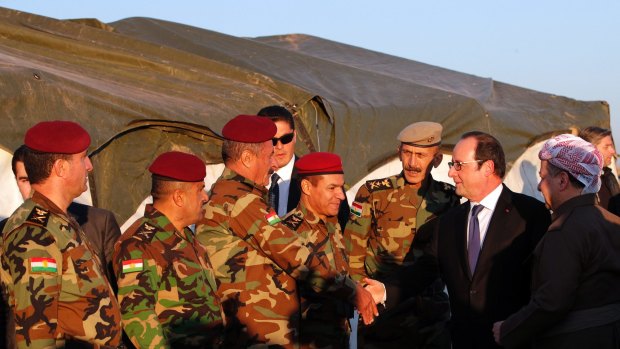 President of the Iraqi self-ruled Kurdish region, Massoud Barzani, right, introduces then French President Francois Hollande to Kurdish Peshmerga soldiers in January.