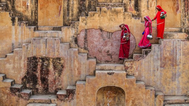 Indian women carrying water from a stepwell.