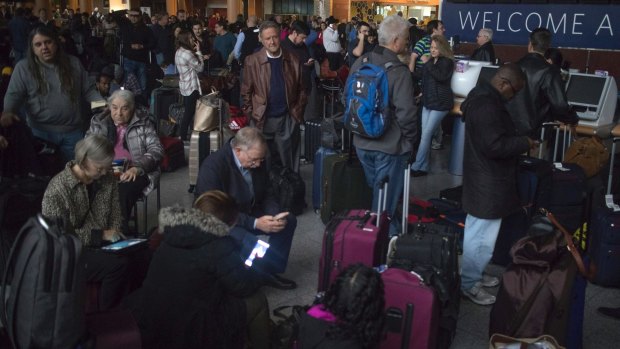 Passengers wait in a dark terminal at Hartsfield-Jackson International Airport during the power outage.