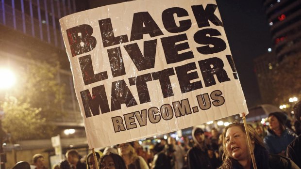 Protesters hold a sign during a march against the New York City grand jury decision to not indict the police officer in the death of Eric Garner, in Oakland, California.