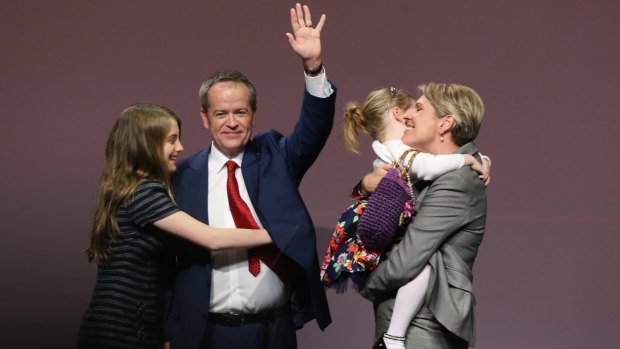 Opposition Leader Bill Shorten is hugged by his daughter Georgette as his other daughter Clementine embraces Deputy Opposition Leader Tanya Plibersek after the ALP National Conference on Friday.
