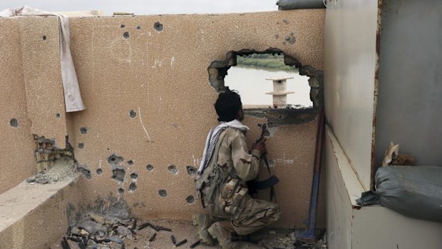 An Iraqi soldier guards a checkpoint in Tikrit.