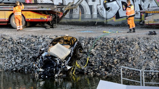 The badly damaged car was retrieved from a canal under the E4 highway bridge in Stockholm on Saturday. 