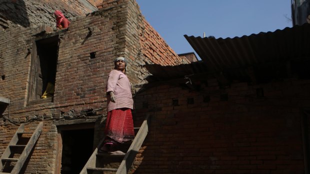 A woman works on reconstructing her house in Bhaktapur, Nepal, after it was damaged by the 2015 earthquake.
