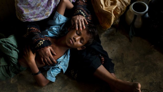 A Rohingya woman comforts her son as they take shelter inside a school after having just arrived from the Myanmar side of the border at Kutupalong refugee camp, Bangladesh.