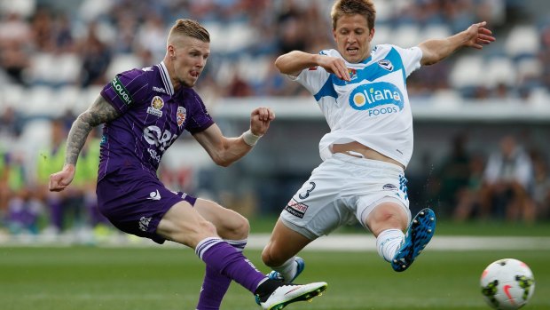 Andy Keogh of Perth Glory scores as Adrian Leijer of Melbourne Victory tries to defend in vain during the A-League match in Geelong on Friday.