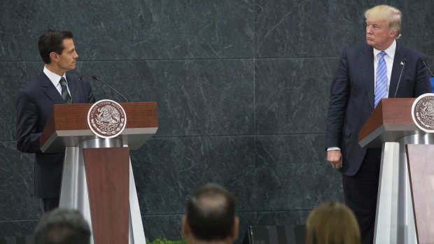 Mexican President Enrique Pena Nieto, left, looks at Donald Trump during a press conference in Mexico City.