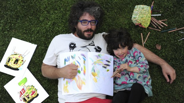 Artist Paul Summerfield and daughter Sumi Zemita, 4, with some examples of the work in his new colouring book.