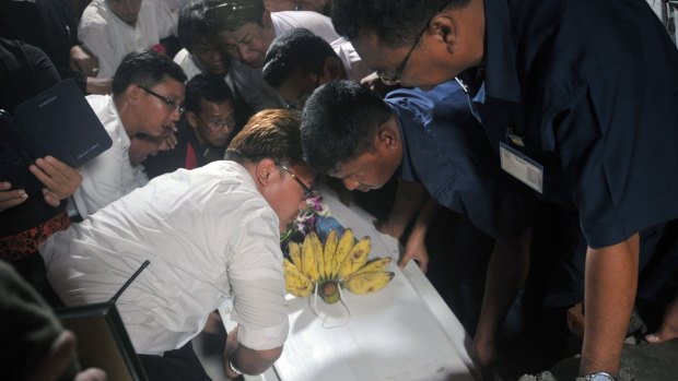 Activists and workers place the coffin of journalist Aung Naing, also known as Par Gyi, into a tomb on Friday in Yangon following his exhumation and autopsy. Myanmar's military has accused him of being part of a rebel group, but his supporters insist he was reporting on violence in Mon state.