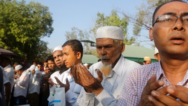 Myanmar Muslims pray on Monday as they bury the body of Ko Ni, who was assassinated on Sunday.