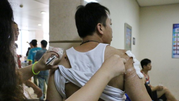 Charlie Zhang, 32, gets a tetanus shot after being injured in the blast.