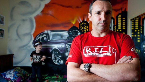 Commercial graffiti artist Ashley Goudie (right) and three-year-old Braxton Vella (left) with the vintage GT Ford Falcon Goudie painted in Braxton's Melton bedroom. 
