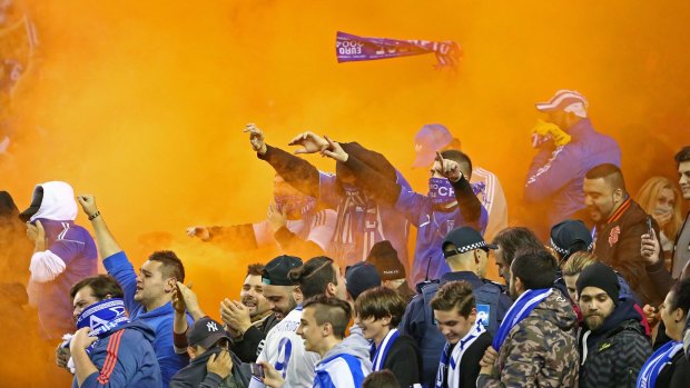 A flare is set off among Greek supporters in the crowd.
