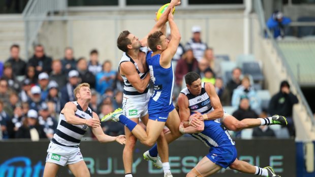 Geelong's Jared Rivers flies high to spoil a mark by Shaun Higgins of the Kangaroos.