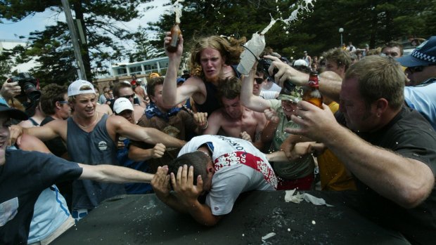Geoffrey Atkinson, wearing a green shirt and camouflage cap, joins the mob of men attacking Safi Merhi during the Cronulla riots.