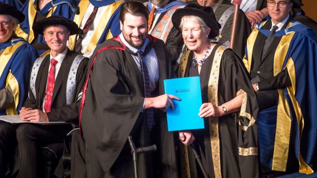 Canberra man and paraplegic Paul Jenkins accepts his degree from University of Canberra Deputy Chancellor Dr Sarah Ryan.