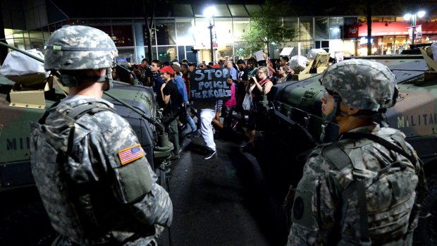 National Guard members watch as protesters march down Tyron Street in Charlotte.