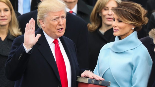 Donald Trump, watched by his wife Melania, is sworn in as the 45th president of the United States.
