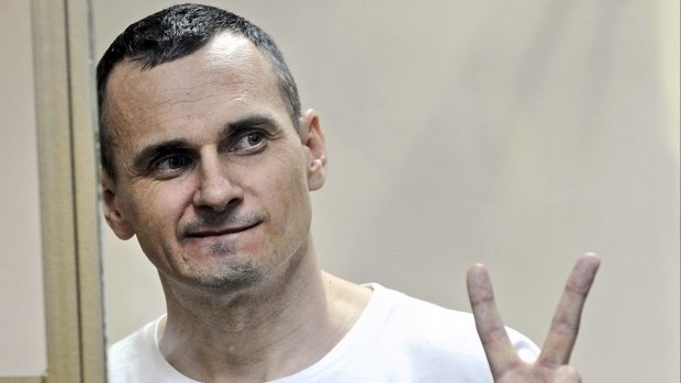 Oleg Sentsov gestures as the verdict is delivered, as he stands behind bars at a court in Rostov-on-Don, Russia, on Tuesday. 