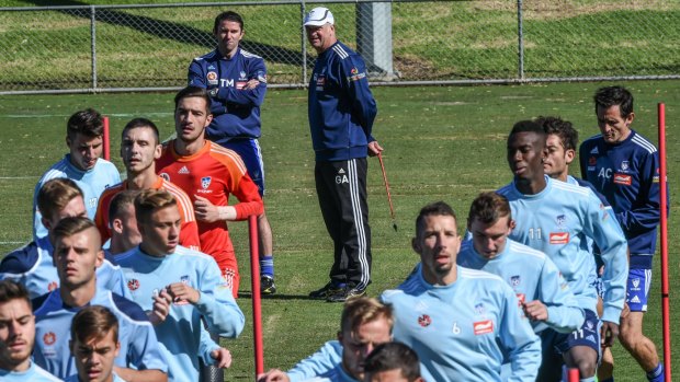 Sydney FC players train under the watchful eyes of Terry McFlynn and coach Graham Arnold on Wednesday.