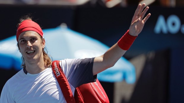 Lukas Lacko waves to the crowd after his victory.