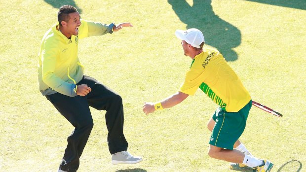 Nick Kyrgios races on court to join the celebrations.