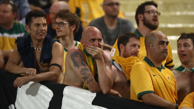 Australian supporters in the crowd watch on dejected.