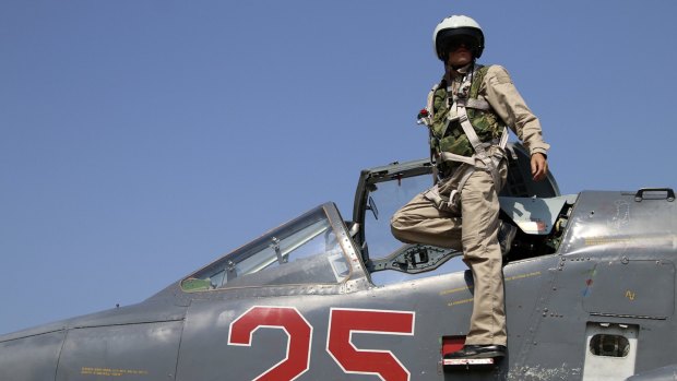 A Russian army pilot poses on the cockpit of an SU-25M jet fighter, similar to the one shot down by Turkish F-16s, at the Hmeimim Airbase in Syria. 
