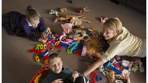 Andrea Faragher and her children Jake and Alysha play with their toys. Ms Faragher believes their toys are lacking in diversity.