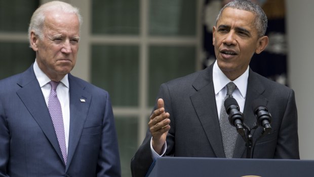 Major victory for his legacy ... President Barack Obama (right), accompanied by Vice-President Joe Biden, talks about the US Supreme Court's decision to protect the Affordable Care Act. 