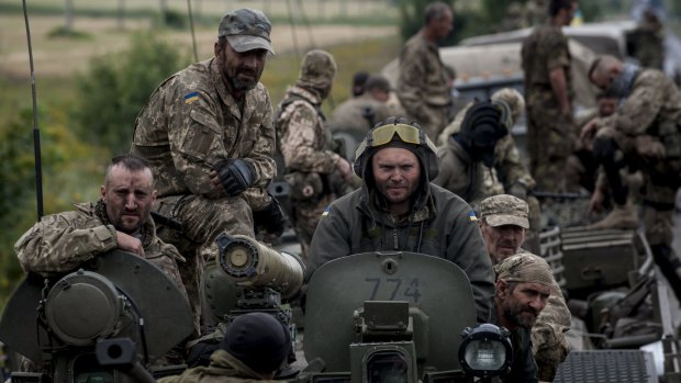 In this photo taken Tuesday, Ukrainian soldiers on board armoured vehicle in the Donetsk region on Tuesday. 