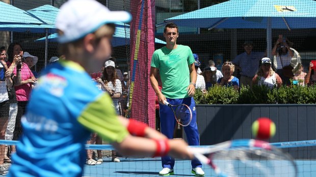 Bernard Tomic practises with kids at Melbourne Park on Saturday.