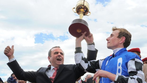Andreas Wohler and jockey Ryan Moore pose with the trophy after Protectionist won the Melbourne Cup on Tuesday.