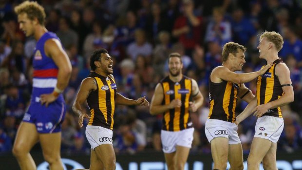 Hawks Cyril Rioli, Sam Mitchell and James Sicily celebrate after the game.